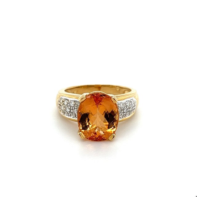 A vintage topaz and diamond ring, set in 18k solid yellow and white gold, containing a natural oval cut orange topaz. The...