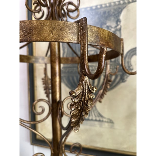 Elegant vintage metal hall stand with a warm gilt-toned finish, decorative scrollwork, and a beautifully ornate...