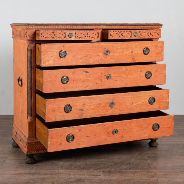 Early 19th century tall chest crafted in pine and fitted with six drawers. Decorative carving accents the top two drawers...
