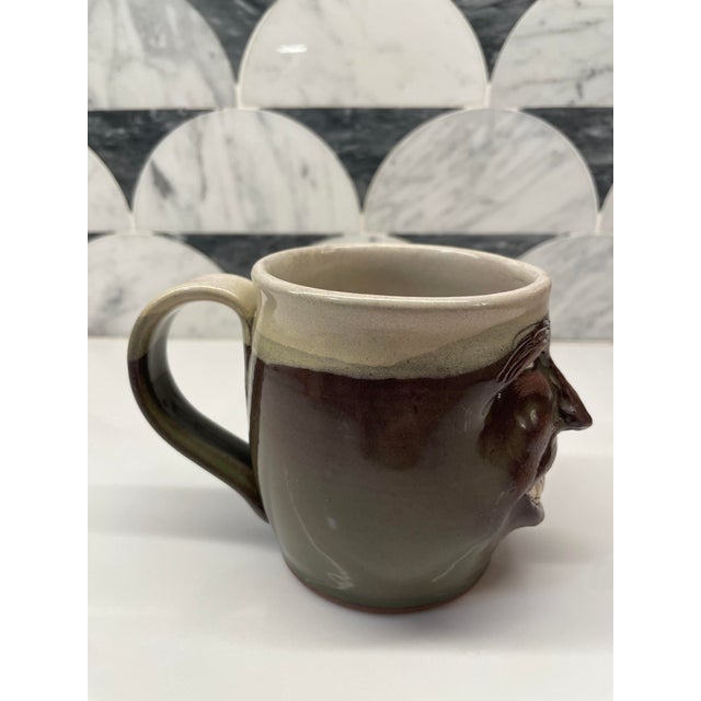 Ceramic mug with a grinning face. Tate Walton Pottery, Ruffin, NC.