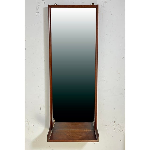 Mid-century modern wall mounted mirror in walnut with storage vanity shelf, circa 1960s. Craft-made, in the manner of...