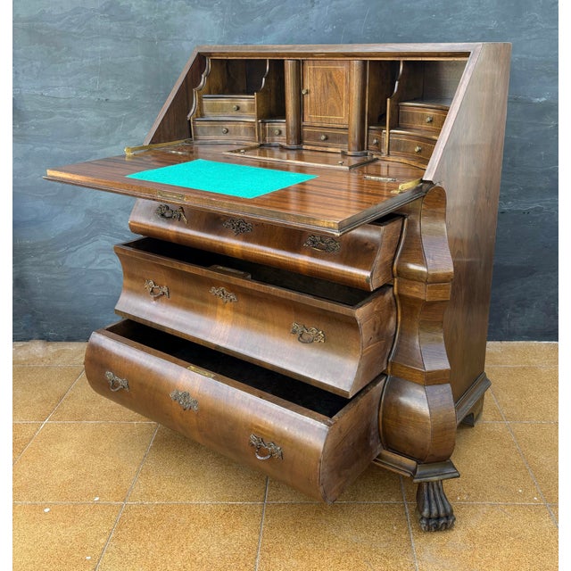 Elegant baroque style bureau desk featuring a distinctive bombe front and a drop-front writing surface. The interior...