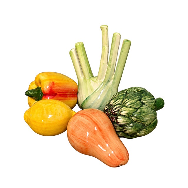 A colorful collection of 11 handmade and hand-painted ceramic fruit and vegetable sculptures, crafted in Italy. The...