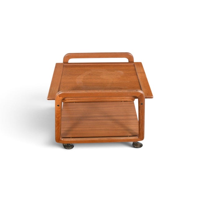 This flip top bar cart was made in Denmark during the 1960s, combining a teak frame with a cream laminate top that flips...