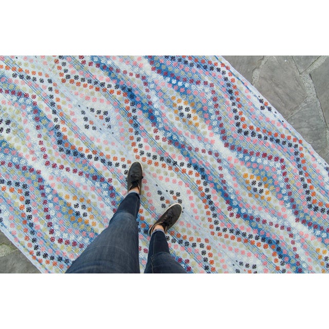 We love the colors on this embroidered vintage kilim with dominant blue hues alongside the play of orange, black, plum,...