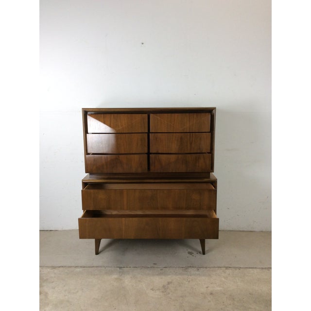 This mid century modern highboy dresser by United Furniture Co. features hardwood construction, original walnut finish,...