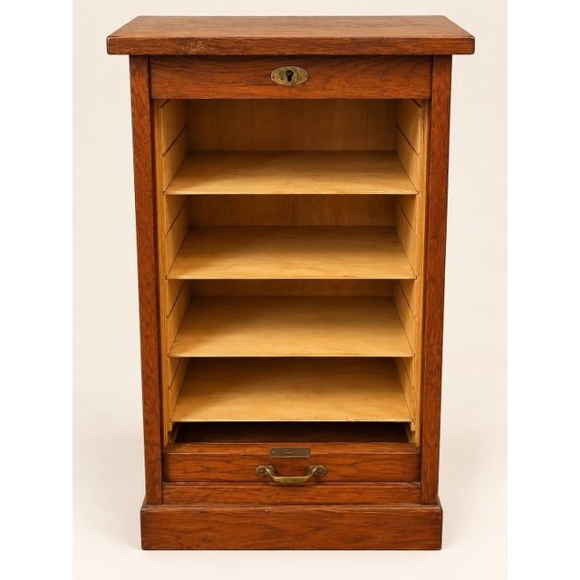A superb small roll-top filing cabinet in the traditional office style, crafted from solid oak with golden-amber...
