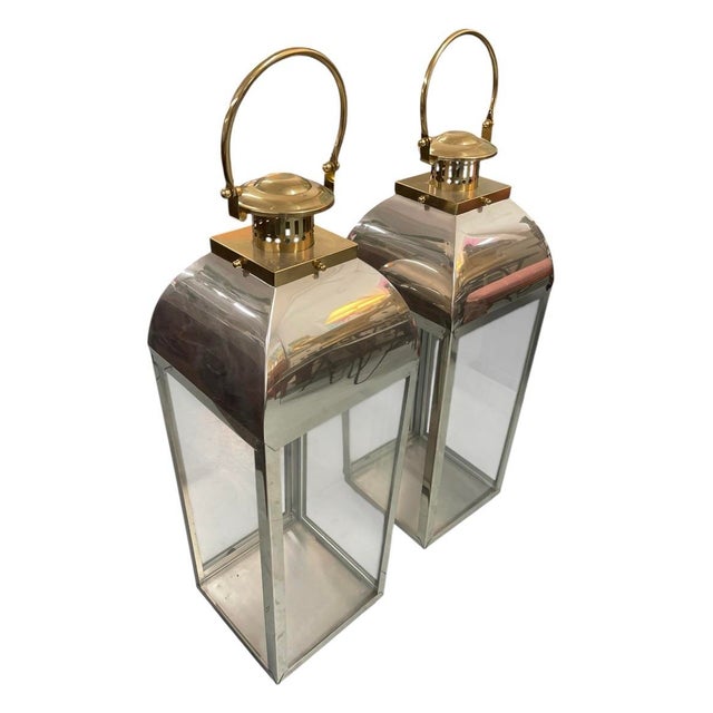 A striking pair of vintage, large-scale floor lanterns, blending classic maritime design with a sophisticated Hollywood...