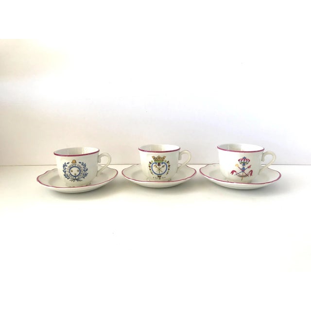 A set of 3 vintage French teacups and saucers, hand-painted with French Revolutionary motifs: 1. With a medallion of oak...