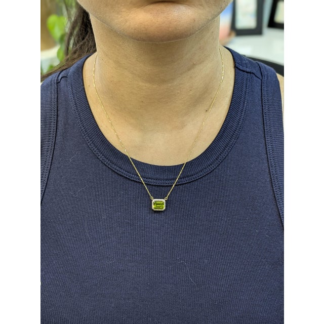 This vibrant necklace features a 2.34ct emerald-cut Peridot from Arizona, measuring 9 x 7mm. Set in 14k gold (2.37g), the...