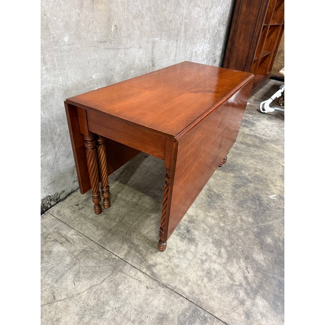 Handsome antique American Federal / Sheraton cherry drop-leaf dining table, circa 1820–1830. The table is built on six...