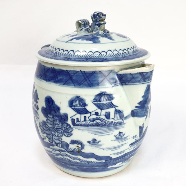 A fine antique Chinese Export porcelain cider jug. In the Canton pattern. Decorated in underglaze blue with a mountainous...