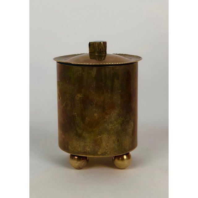 A unique brass cigarette container from the 1920's hand made in Austria. On top of the lid is a glass stone in turquoise...