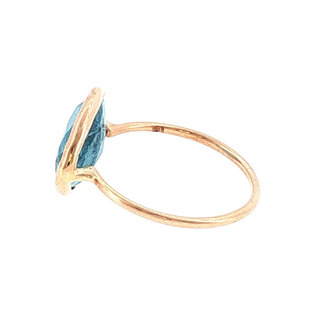 A 21st-century gold ring featuring a triangular mixed-cut aquamarine stone. The band is slender and smooth, showcasing a...