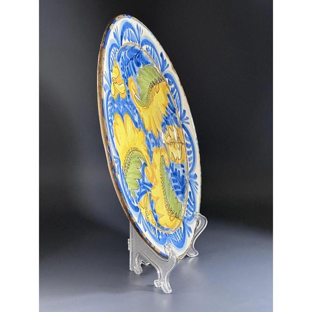A large-scale spanish maiolica earthenware charger expressively and beautifully decorated with traditional motifs with...