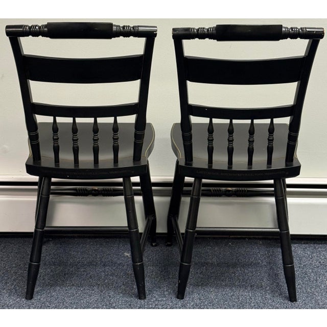 Beautiful pair of traditional Hitchcock chairs featuring a rich black finish accented with intricate gold floral...