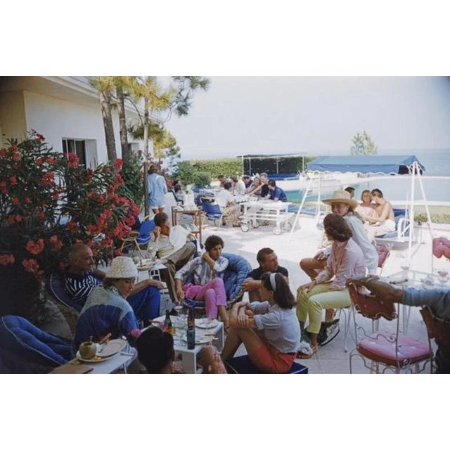 Riviera Crowd 1957 by Slim Aarons Slim Aarons Limited Estate Edition Holidaymakers enjoying lunch by a pool on the French...