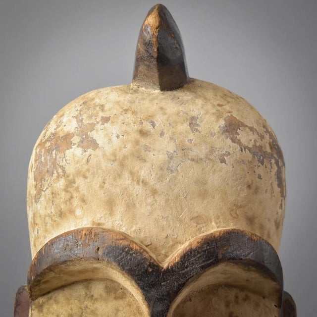 The Fang face mask, displaying wear both on its surface and interior, signifies its age and extensive use.Â It is crafted...