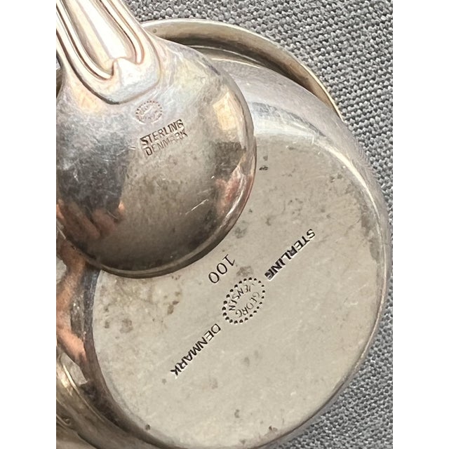 Georg Jensen. Design by Harald Nielsen. Denmark. two salt shakers and a spoon hallmarked silver with a total weight of the...