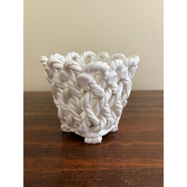 An elegant trompe l'oeil porcelain cachepot crafted in the form of a handwoven rope basket. Executed in glossy white...