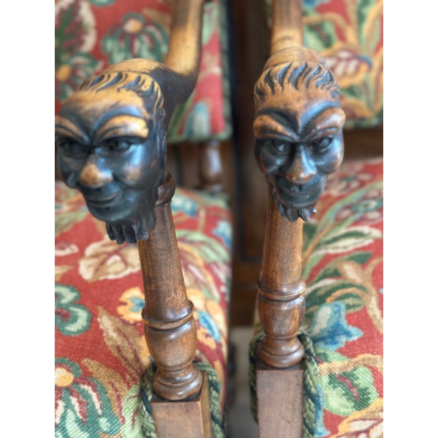 An exceptional pair of antique Louis XIII-style carved walnut fauteuils featuring rare and expressive figural mask arm...