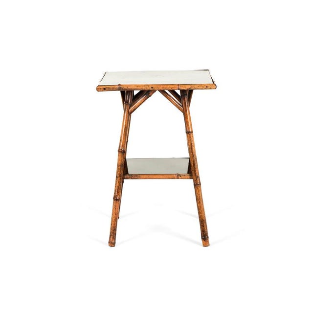 A Victorian bamboo side table with two lacquer work tiers on splayed legs with triangular supports. Strong and sturdy and...