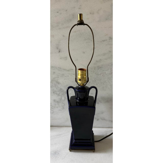 Vintage urn style ceramic cobalt blue table lamp with curved handles and a footed brass base. Height to top of socket is...