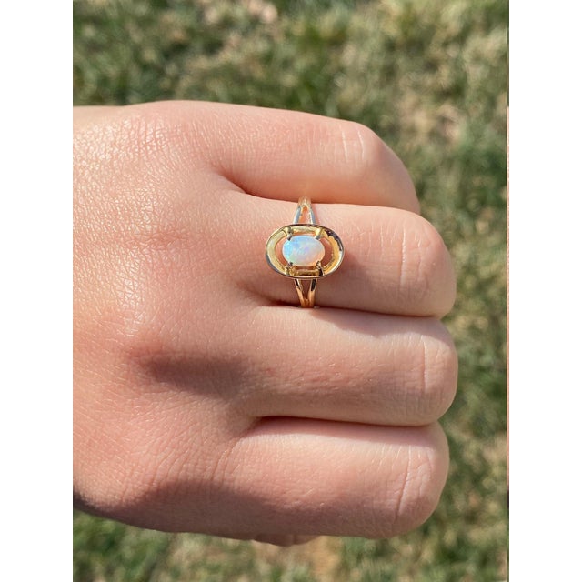 The Calera: Ladies Yellow Gold Australian Opal Ring. Crafted in trendy yellow gold, this ring features an oval Australian...