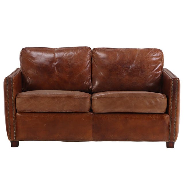 A classic leather club sofa featuring warm, aged leather upholstery. The generous proportions, gently squared arms, metal...