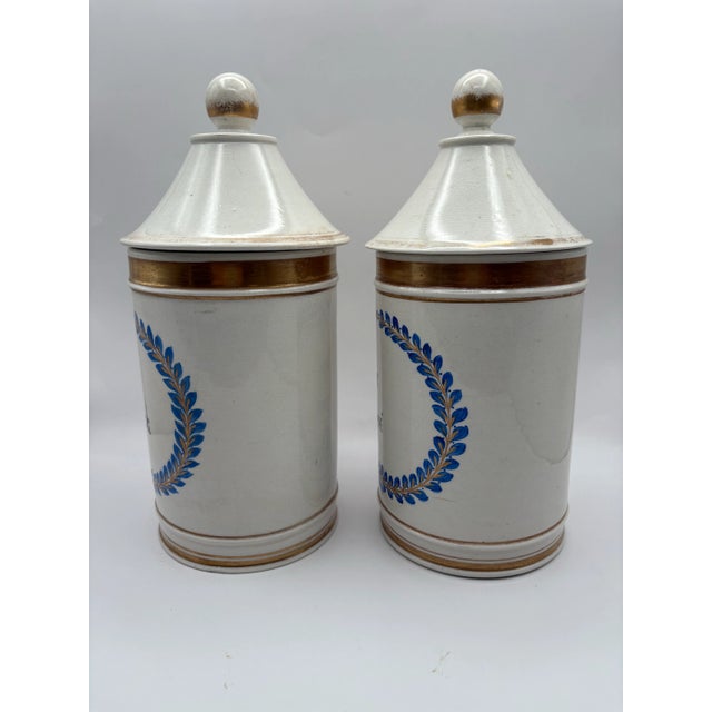 Set of two European Apothecary Jars with decorative blue and gold hand painted detailing and lettering. Both jars have...