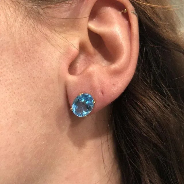 Beautiful Swiss Topaz oval solitaire studs in solid 14k gold. The featured swiss blue topaz sparkles excellently in these...