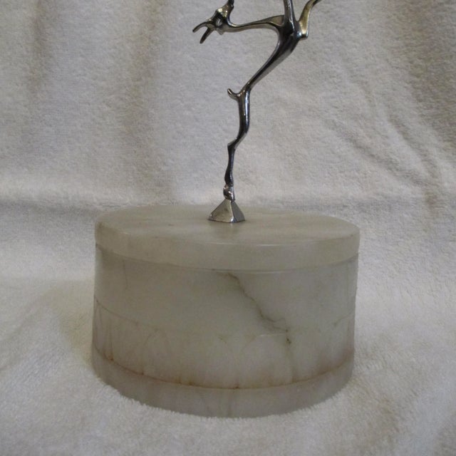 Carved in alabaster with a decorative lotus band around the base of the walls. The top handle is a chromed figure of a...