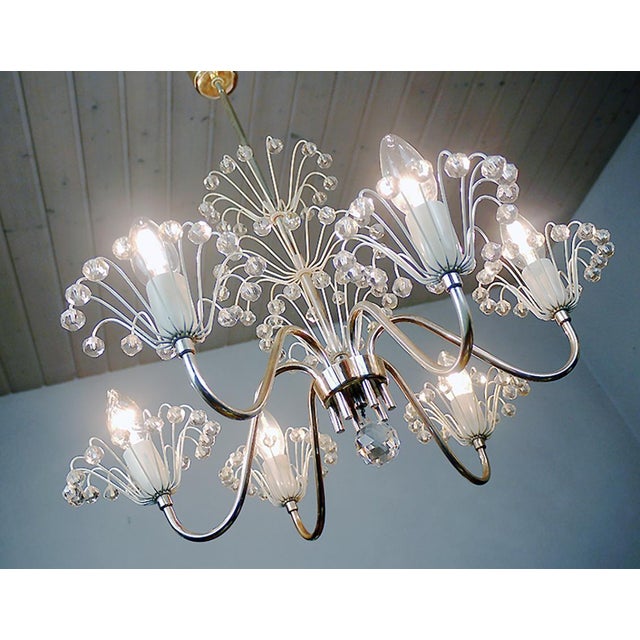Elegant pyra chandelier constructed of brass with cream colored painted florets and socket covers accented with crystal...