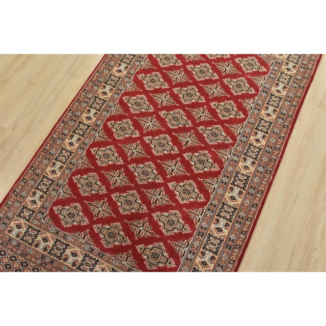A tribal Bokhara Jaldar rug hand-knotted with fine wool on a cotton foundation. This rug features rows of repeating...