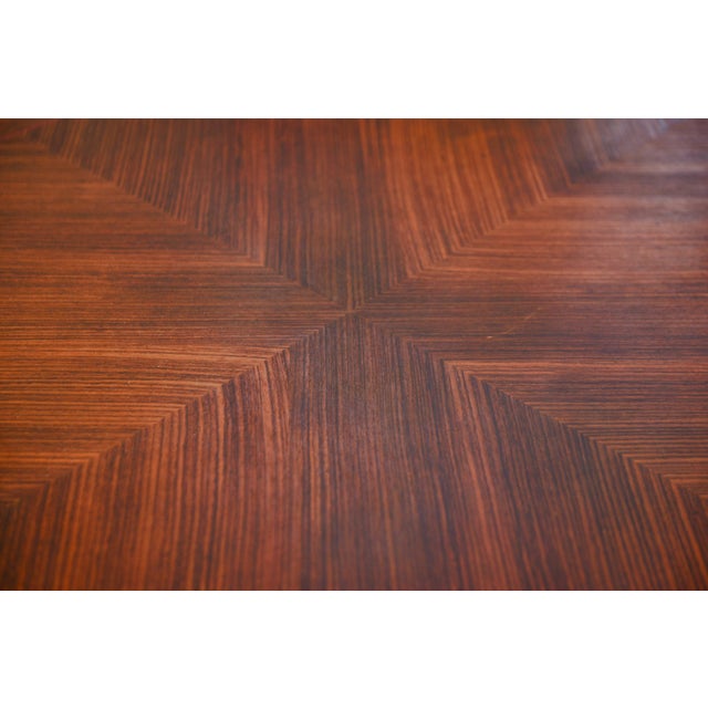 A 1930s Art Deco wooden table with a geometric design characteristic of the period. The rectangular top features a...