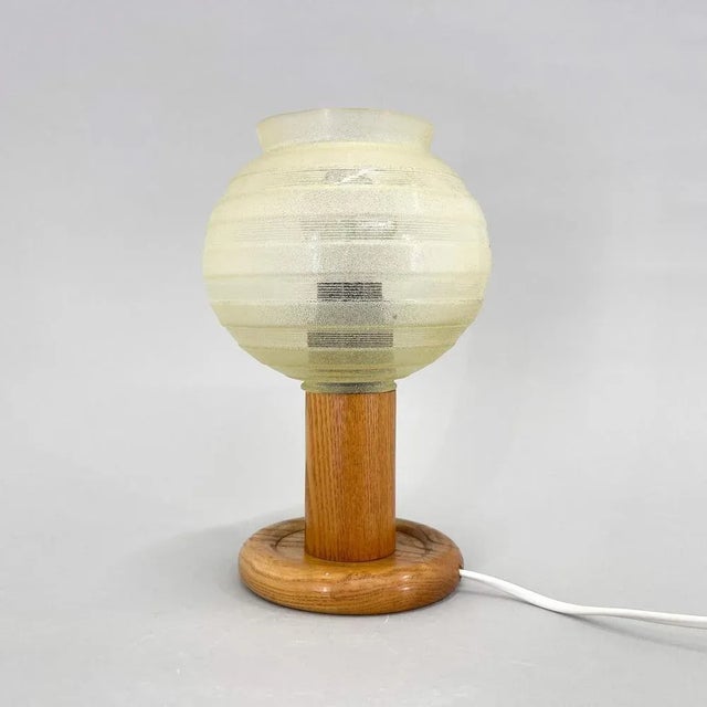 Vintage table or bedside lamp, made of wooden base and glass lamp shade. Produced in former Czechoslovakia in the 1970s....