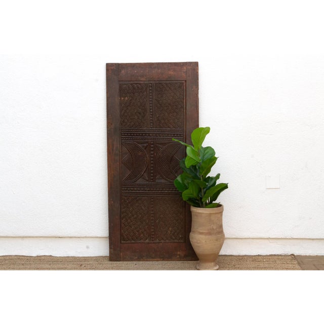 At the center of this Igbo door from the Awka guild tradition of Anambra State sits a pair of facing crescents, carved...