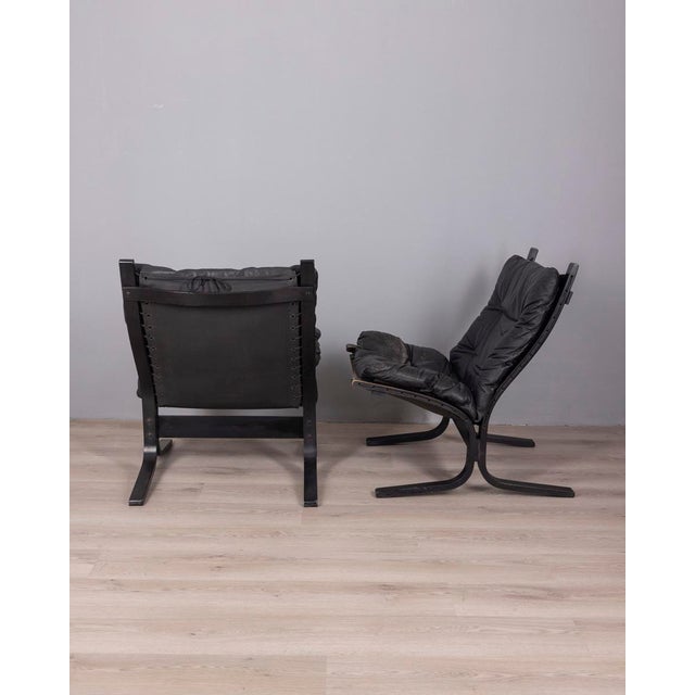 Pair of armchairs with wooden frame and black leather upholstery, "Siesta" model, designed by Ingmar Relling for Westnofa,...