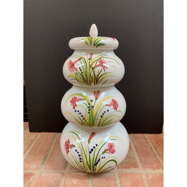 This tower of Italian glazed terra-cotta stacking jars features a lovely hand painted floral design on a white glaze...