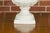 A pair of Blanc de Chine urns from the Midcentury period, with rams heads handles, grapes and ivy motifs. This pair of...