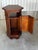 A hexagonal mahogany side table, 20th century. Molded top, open niche, and lower storage compartment with a door. Molded...