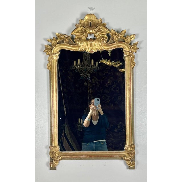 19th century French giltwood mirror. The mirror is beautifully carved with tiny flowers flanking a center acanthus leaf...