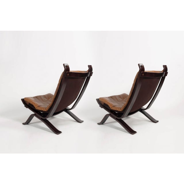 A pair of original Focus sling-type lounge chairs, manufactured by Bramin Møbler in the 1970s. The chairs contain cognac-...