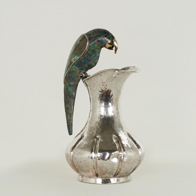 Mid century pitcher handcrafted in silver plate on hammered copper in modern form featuring a parrot as a handle clad in a...