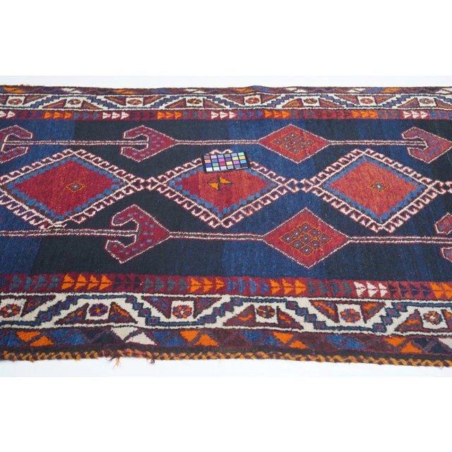 The magnificently abrashed, pellucid royal blue field shows a bold three column pattern of a pole medallion of five red...