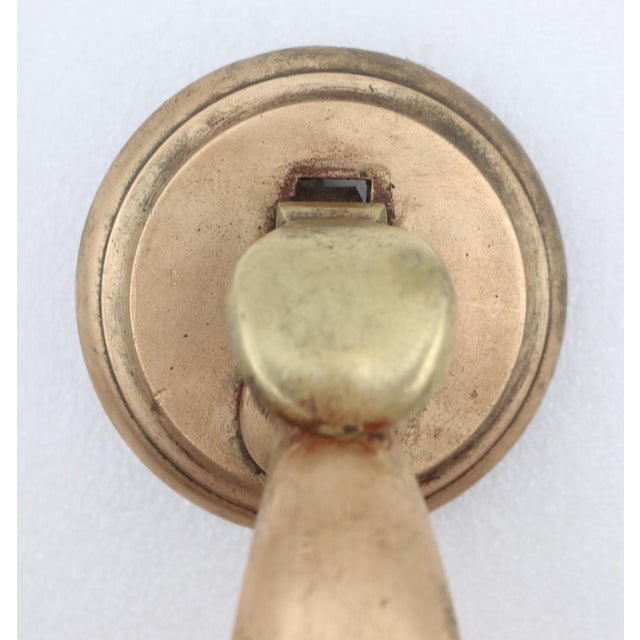 Vintage polished brass thumb latch door pull with a curved shaped handle and round plates. The original mounting screws...