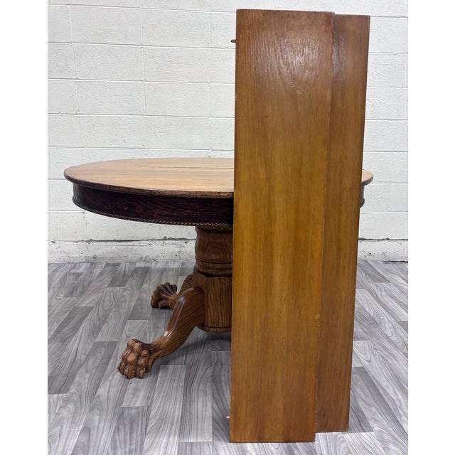 This is a gorgeous antique 48 inch Victorian tiger oak round claw foot pedestal dining table featuring an impressive...