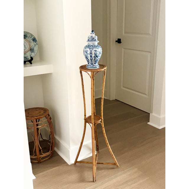 Vintage Palm Beach Style Rattan & Bamboo Two-Tiered Plant Stand CIRCA: Mid-20th Century MAKER'S MARK: None CONDITION: Good...