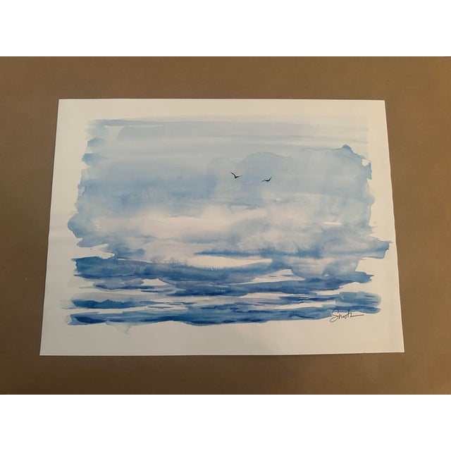 Original watercolor painting capturing the quiet beauty of an expansive blue seascape beneath a softly layered sky. Loose,...