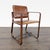 This lounge chair features a sturdy curved wooden frame and a rich brown leather seat and backrest. The armrests and...